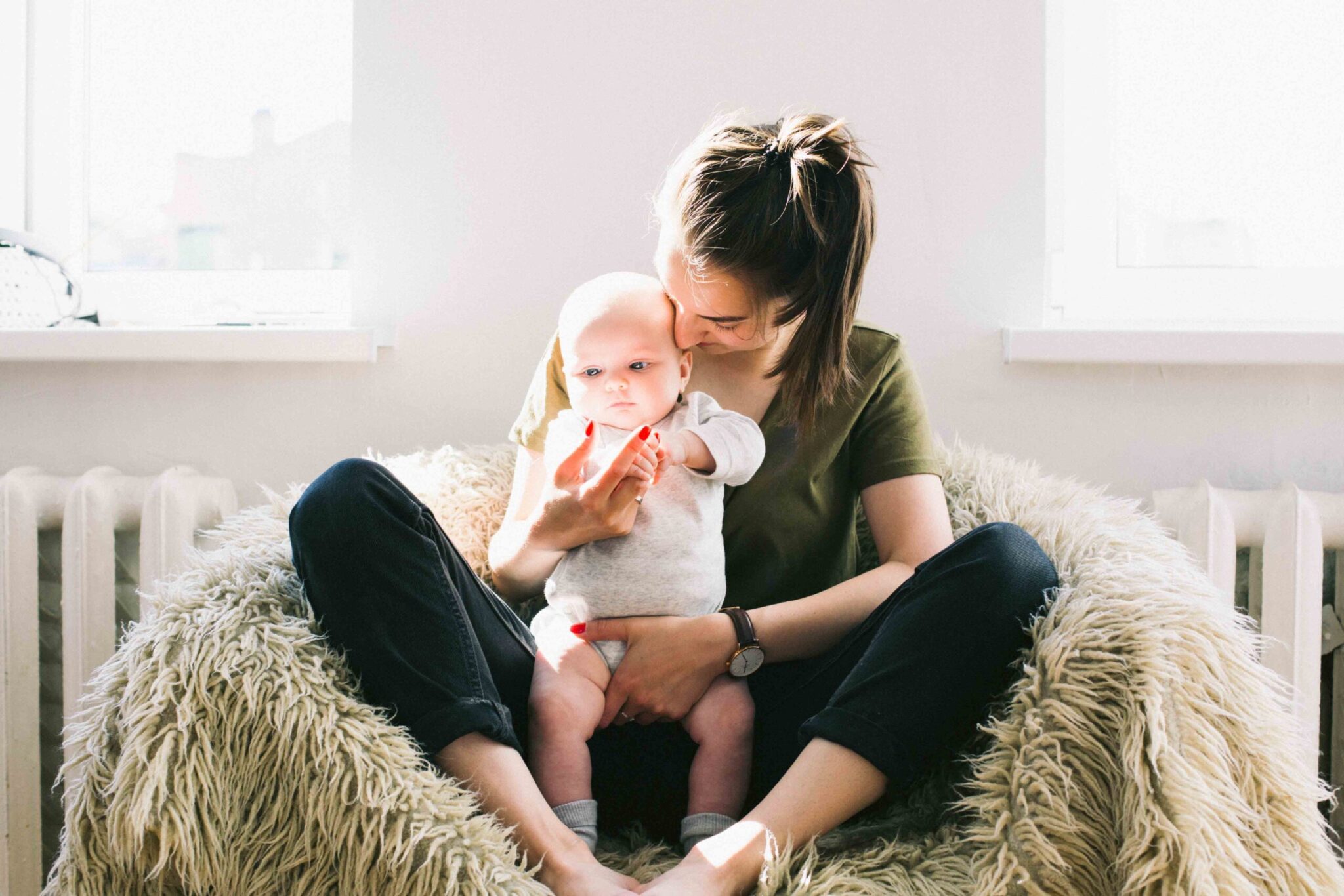 woman-holding-baby-while-sitting-on-fur-bean-bag-698878kicsi
